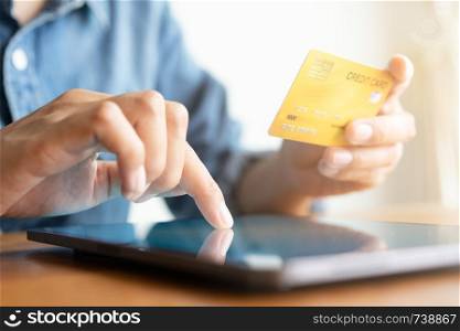 Close up hand of businessmen are buying online with a credit card. Men are using tablet and doing online transactions.