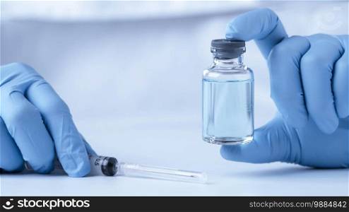 Close up hand of doctor holding Vaccine and syringe injection. Healthcare And Medical concept.