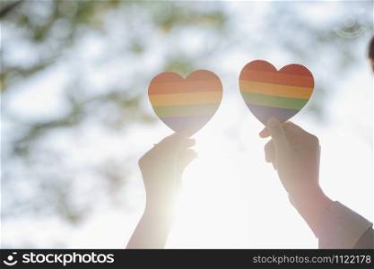 Close up hand of LGBTQ couple holding rainbow heart. LGBT rights concept.