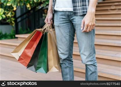 Close up hand of male holding multiple shopping bags colorful shopping bag, New normal lifestyle and shopping concept