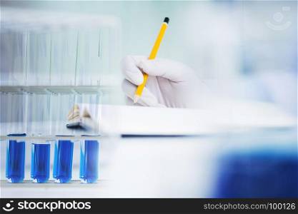 close up hand of medical chemist / scientist student experiments test tube in laboratory, selective focus