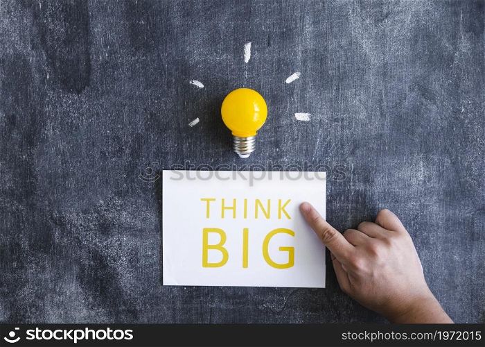 close up hand pointing finger think big with light bulb chalkboard. High resolution photo. close up hand pointing finger think big with light bulb chalkboard. High quality photo