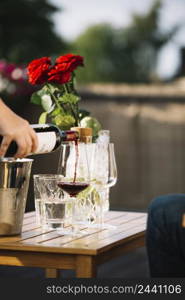 close up hand pouring wine transparent glass wooden table