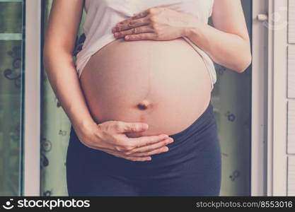 close up hand pregnant woman holding her tummy