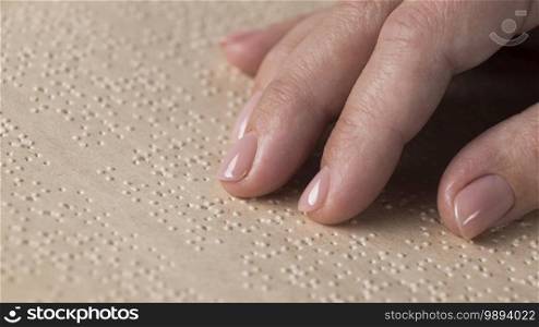 Close-up hand reading braille