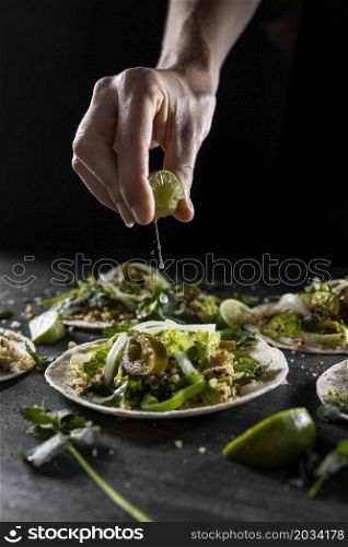 close up hand squeezing lime taco
