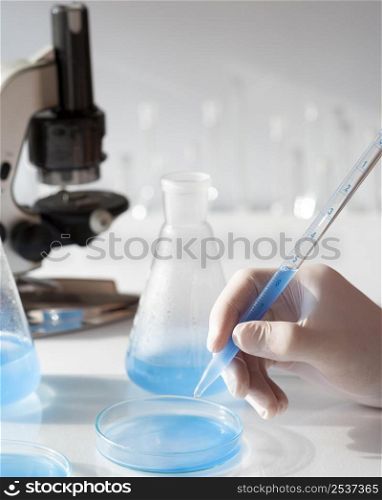 close up hand with glove wearing pipette