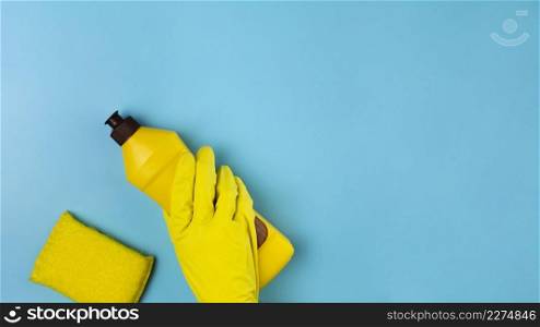 close up hand with yellow glove blue background