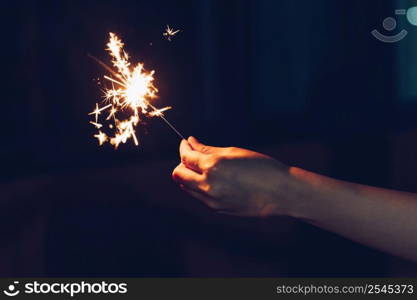 Close up hand woman holding sparklers in night party and christmas celebration.