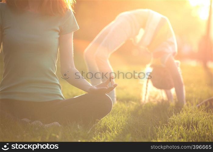 Close up hands. Healthy lifestyle -mom and daughter doing yoga in the park. Healthy and Yoga Concept