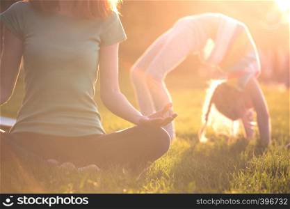Close up hands. Healthy lifestyle -mom and daughter doing yoga in the park. Healthy and Yoga Concept