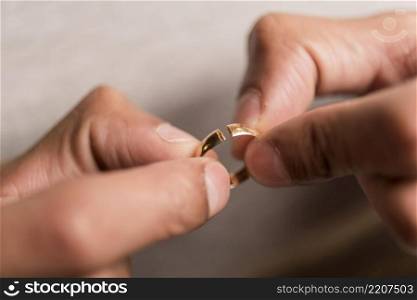 close up hands holding broken ring
