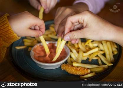 close up hands holding french fries