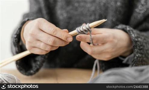 close up hands holding knitting needles