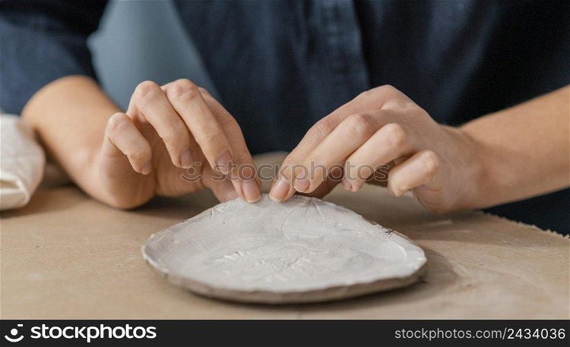 close up hands holding pottery item