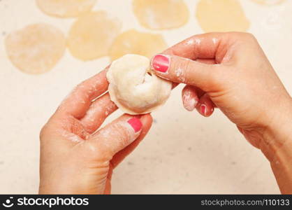 close-up, hands of chef who prepares dumplings from dough