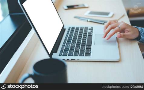 Close up hands of young businesswoman typing on computer laptop with blank screen at the office or cafe, business concept