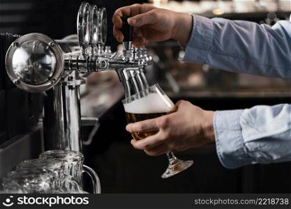 close up hands pouring beer glass