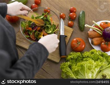 close up hands preparing salad