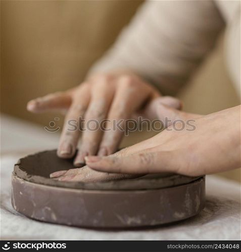 close up hands touching clay