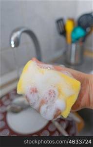 Close up hands with gloves of woman washing dishes
