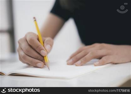 Close up hands with pen writing on notebook. Education concept.