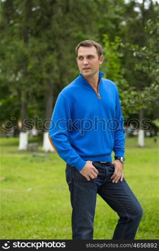 Close up, Handsome young man in blue sweater in the summer park