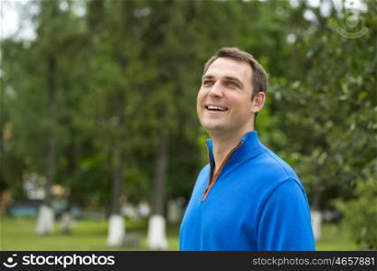 Close up, Handsome young man in blue sweater in the summer park