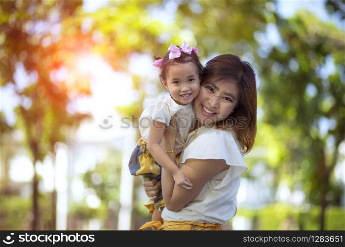 close up happiness face of asian mother and little daughter toothy smiling outdoor
