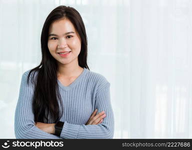 Close up headshot portrait young Asian happy beautiful woman healthy smiling face long hair stand crossed arm, studio shot looking to camera at home and have a copy space