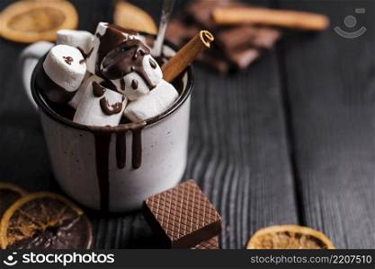 close up hot chocolate with marshmallows cinnamon stick dried orange slices