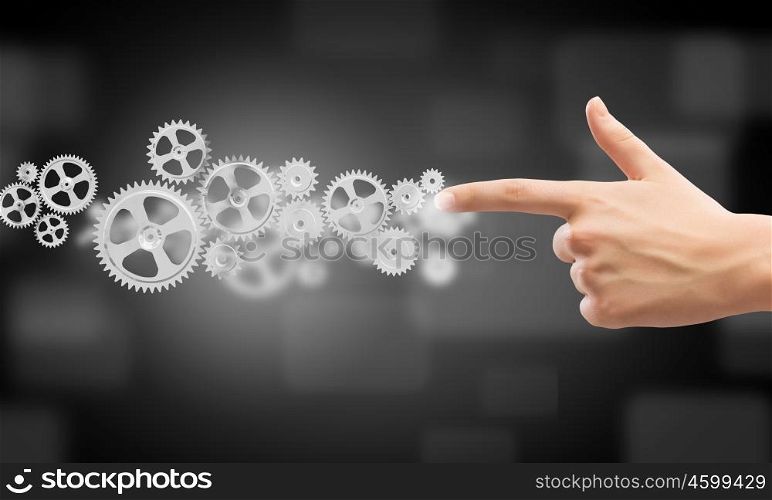 Close up human hand pointing at gears mechanism