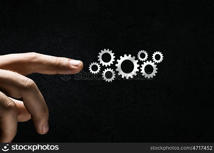 Close up human hand pointing at gears mechanism