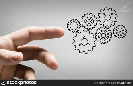 Close up human hand pointing at gears mechanism