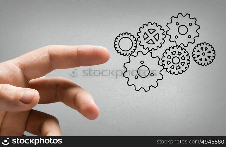 Close up human hand pointing at gears mechanism. That&rsquo;s how it works