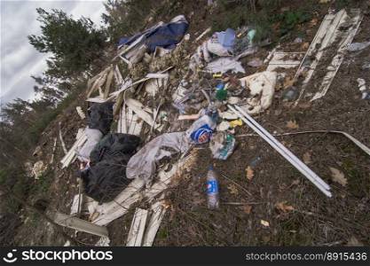 Close up illegally dumping garbage in park concept photo. Forest pollution. Front view photography with blurred background. High quality picture for wallpaper, travel blog, magazine, article. Close up illegally dumping garbage in park concept photo