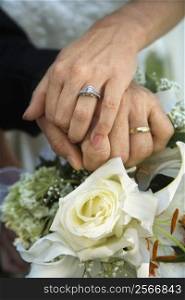 Close up image of bride and groom&acute;s hands overlapping.