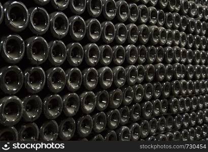 Close up image of champagne bottles in a wine rack while they ferment.
