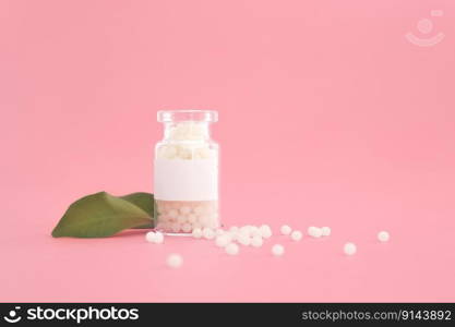 Close-up image of homeopathic globules in glass bottle on pastel pink background. Homeopathy pharmacy, herbal, natural medicine, alternative homeopathy medicine, healthcare. Free space, copy space. Close-up image of homeopathic globules in glass bottle on pastel pink background. Homeopathy pharmacy, herbal, natural medicine, alternative homeopathy medicine, healthcare. Free space, copy space.