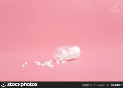 Close-up image of homeopathic globules in glass bottle on pastel pink background. Homeopathy pharmacy, herbal, natural medicine, alternative homeopathy medicine, healthcare. Free space, copy space. Close-up image of homeopathic globules in glass bottle on pastel pink background. Homeopathy pharmacy, herbal, natural medicine, alternative homeopathy medicine, healthcare. Free space, copy space.