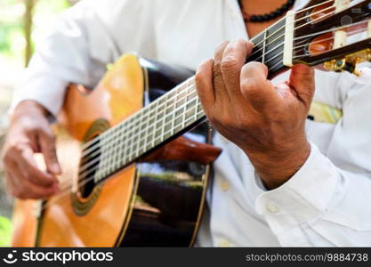 Close up image of Man playing an acoustic guitar 