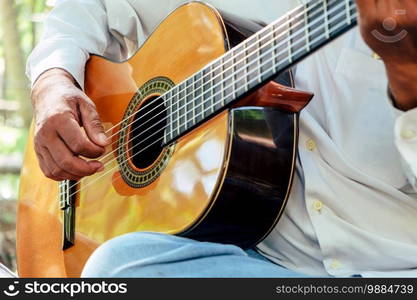 Close up image of Man playing an acoustic guitar 