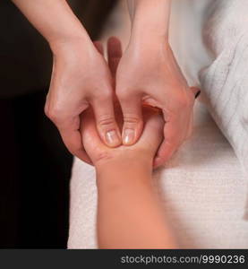 Close up image of physiotherapist massaging female patient hand. Sports injury treatment