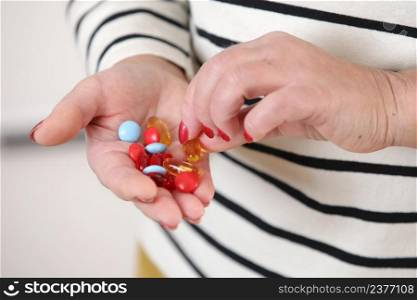 Close-up image of senior womans hand holding capsules of pills, medicine and recovery treatment, copy space. Photo of a elderly woman taking daily medicine. Healthcare concept. Close-up image of senior womans hand holding capsules of pills, medicine and recovery treatment, copy space. Photo of a elderly woman taking daily medicine. Healthcare concept.