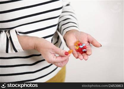Close-up image of senior womans hand holding capsules of pills, medicine and recovery treatment, copy space. Photo of a elderly woman taking daily medicine. Healthcare concept. Close-up image of senior womans hand holding capsules of pills, medicine and recovery treatment, copy space. Photo of a elderly woman taking daily medicine. Healthcare concept.