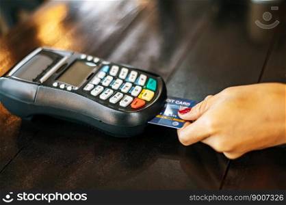 Close-up image of woman paying with credit card in cafe