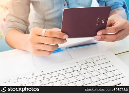 Close up image of woman&rsquo;s hands holding passport book on work sp. Close up image of woman&rsquo;s hands holding passport book on work space desk
