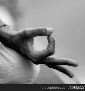 Close up image of woman&rsquo;s hands in lotus position by the lake