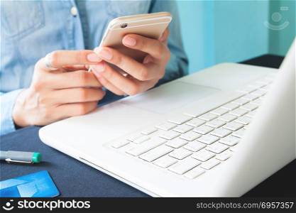 Close up image of woman&rsquo;s hands using smartphone and laptop comp. Close up image of woman&rsquo;s hands using smartphone and laptop computer on workspace desk, Space for text or design