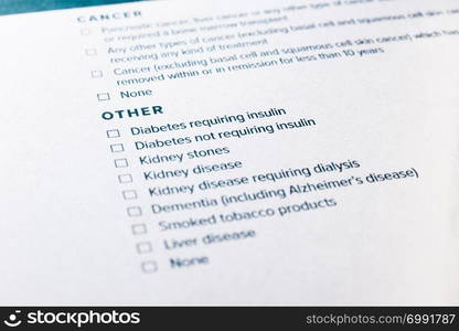 Close up image, selective focus on diabetes and kidney disease content on health insurance questionnaire and application form. Healthcare, insurance policy, personal safety plan and business concepts.